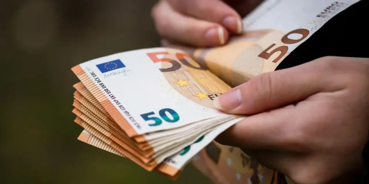 Dłonie trzymają stos banknotów 50 euro. Choć Bułgaria ma swoją walutę, euro jest powszechnie akceptowane.