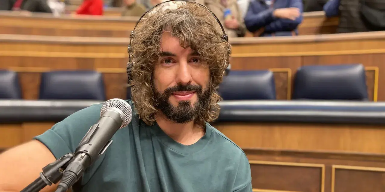 Mikel Izal, con su melena rizada y barba, sonríe ante el micrófono, listo para crear su propio paraíso musical en este escenario.