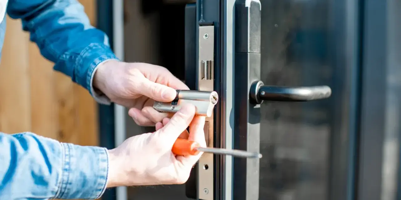 Mani che sostituiscono serratura porta con cacciavite.