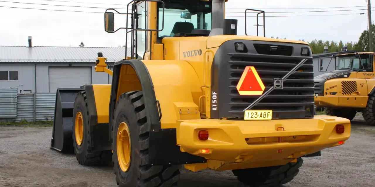 Żółta ładowarka kołowa Volvo L150F z tablicą rejestracyjną 123-ABF.