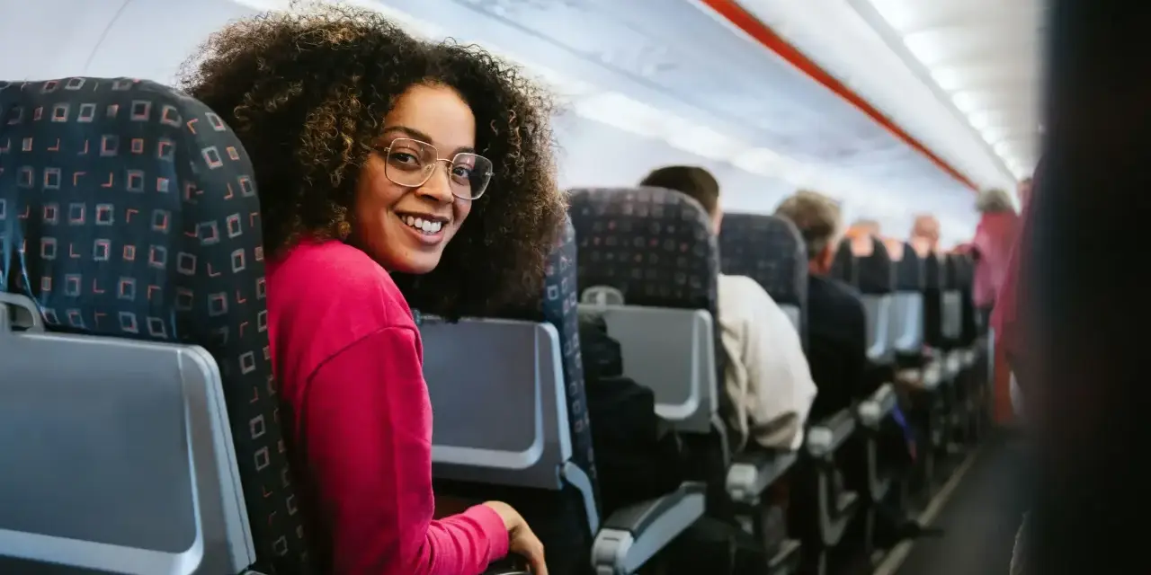 Smiling woman on a discount airlines european flight. She's happy to be traveling affordably.