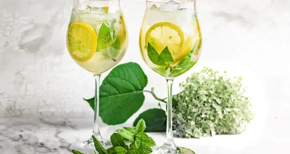 Orzeźwiający drink z prosecco i sprite, z plasterkami cytryny i listkami mięty, podany w kieliszkach. Idealny na letnie popołudnie.