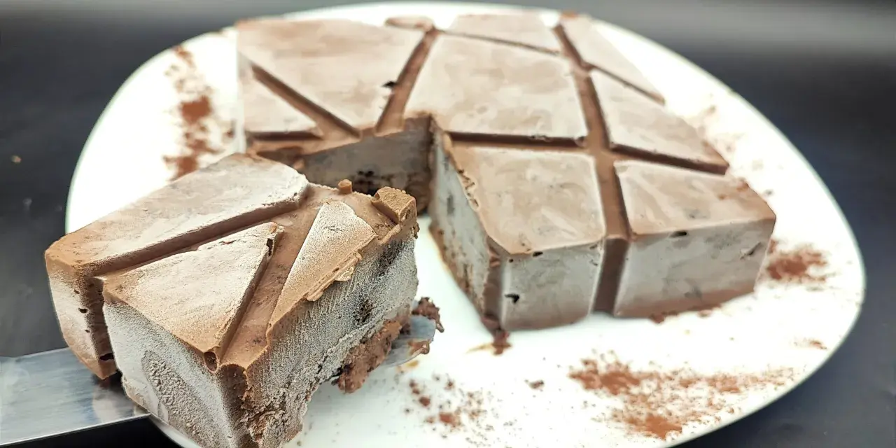 Un delizioso semifreddo al cioccolato, tagliato a cubetti e spolverato con cacao, pronto per essere gustato.