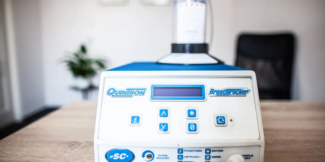 Urządzenie QuinTron BreathTracker do analizy oddechu na stole.
