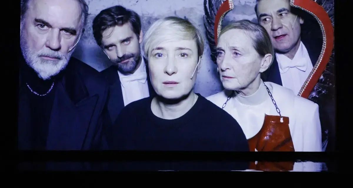 Kazimierz, reżyser i aktor teatralny, w otoczeniu aktorów na scenie.