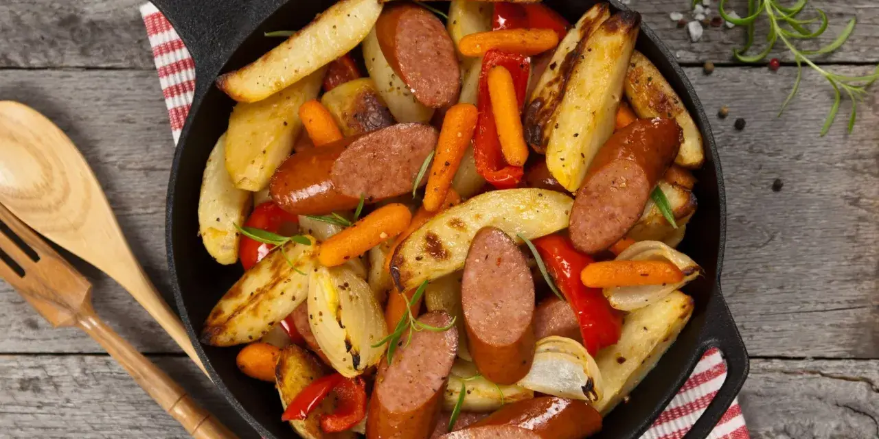 Stare przepisy na obiad: kiełbasa z ziemniakami, marchewką i papryką zapiekane w żeliwnej patelni.