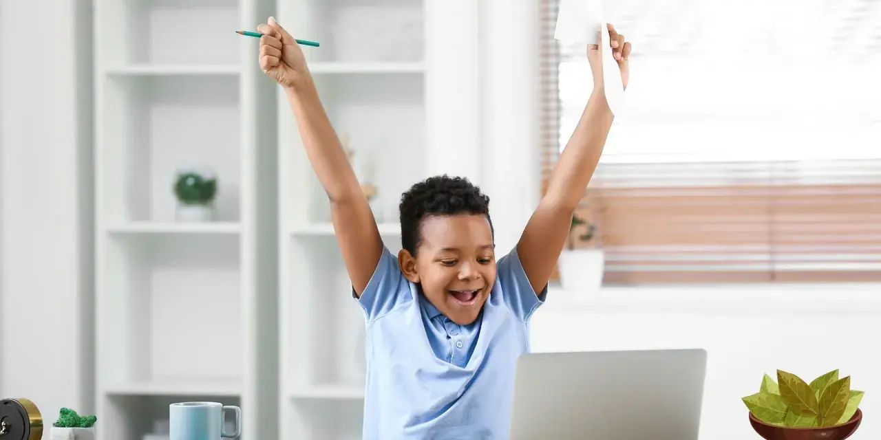 Niño celebra con un lápiz y papel, ¡cosas que dan suerte para un examen!