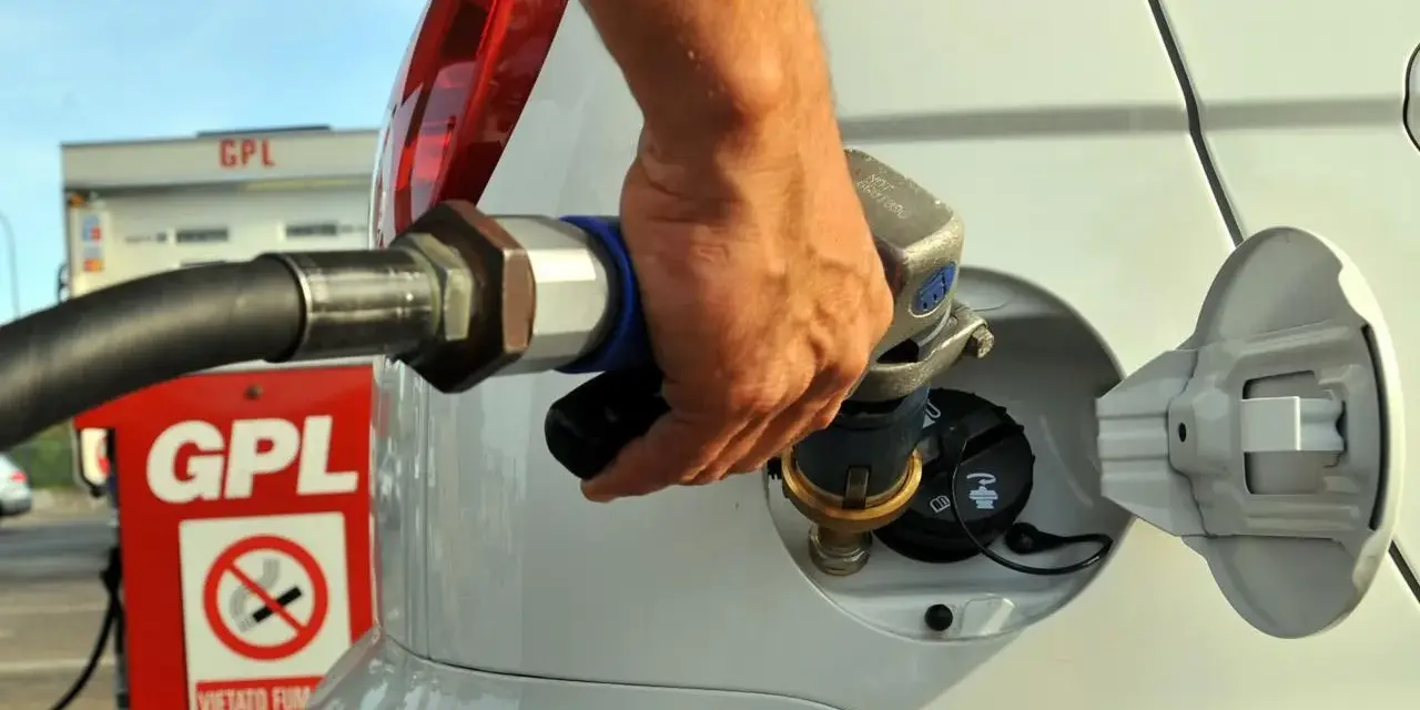 Rifornimento GPL in autostrada. Mano che inserisce la pistola nel serbatoio dell'auto.
