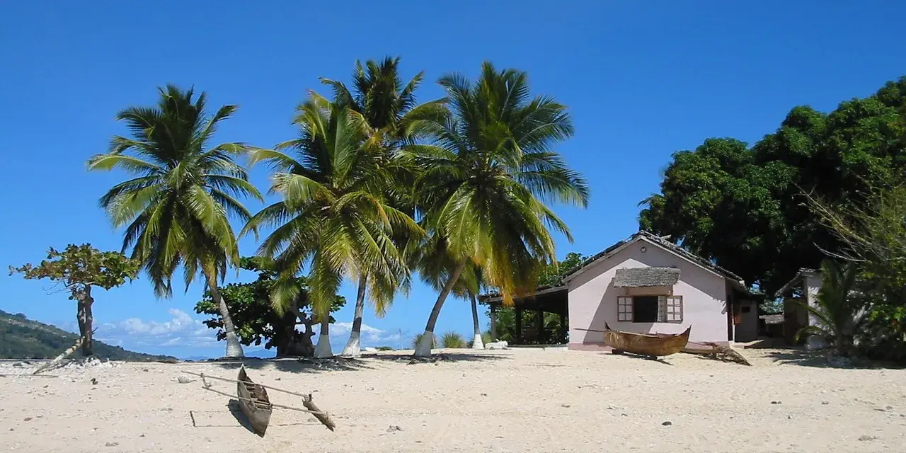 Piękna plaża z palmami i domkiem, idealne miejsce na wakacje. Zastanawiasz się, ile się leci na Madagaskar?