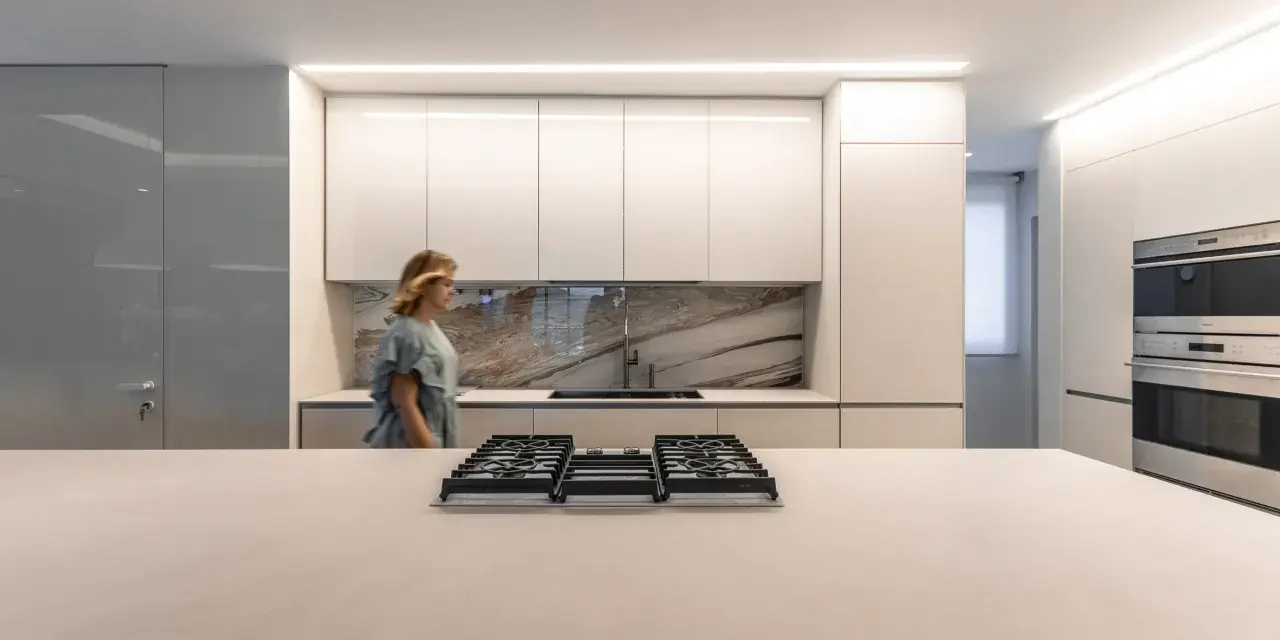 Cocina moderna con iluminación LED integrada en los gabinetes y el techo, ideal para saber como iluminar una cocina.