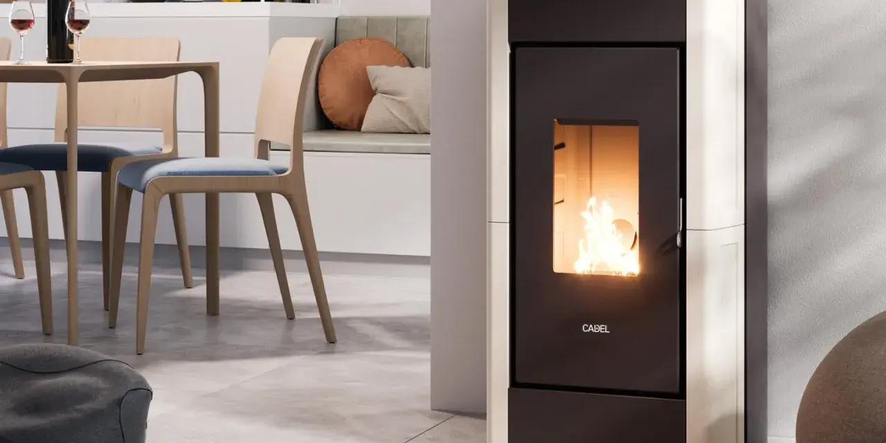 Stufa a pellet moderna in funzione, con fiamme vive. L'installazione stufa a pellet con canna fumaria è discreta, integrata in un ambiente cucina/soggiorno accogliente.