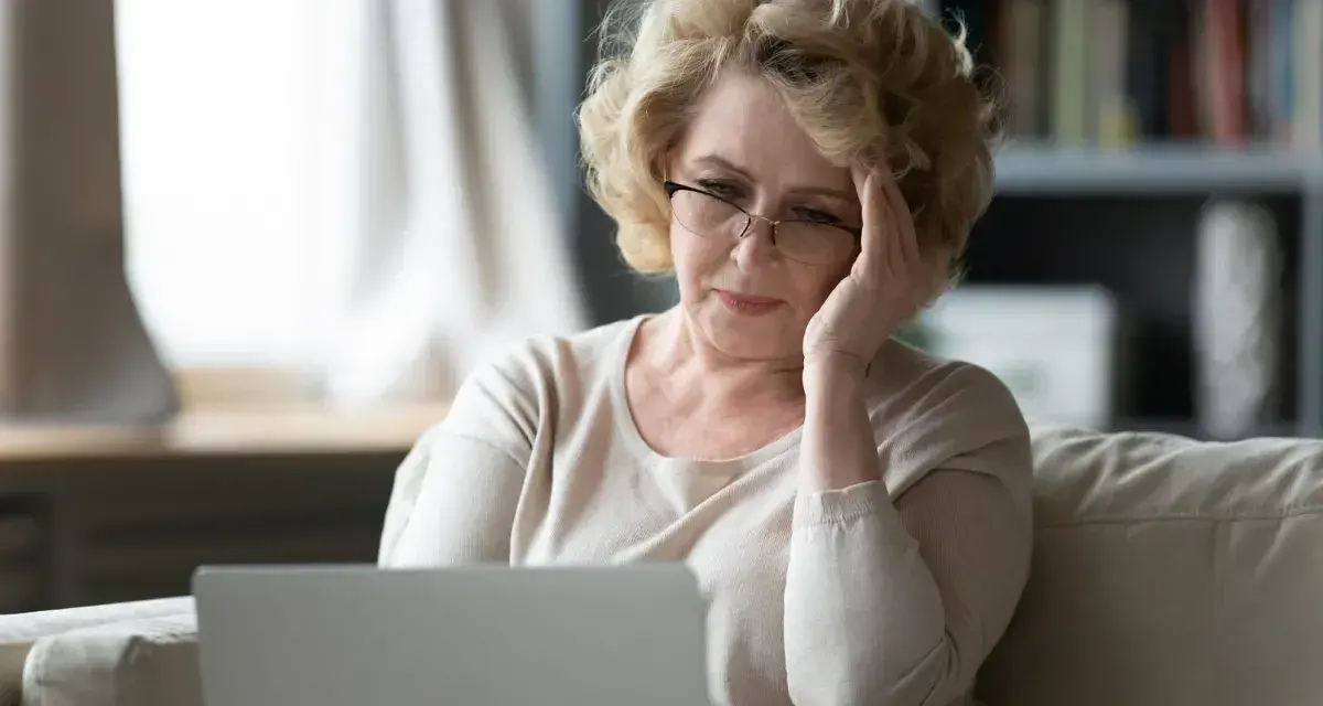 Zmartwiona wdowa po 50. roku życia szuka informacji o rencie rodzinnej online.