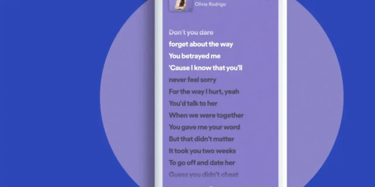 Lyrics von "traitor" von Olivia Rodrigo bei Spotify. Der Songtext wird auf einem Smartphone angezeigt.