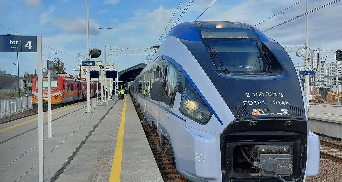 Nowoczesny pociąg PKP Intercity ED161 na peronie, obok innego pociągu.