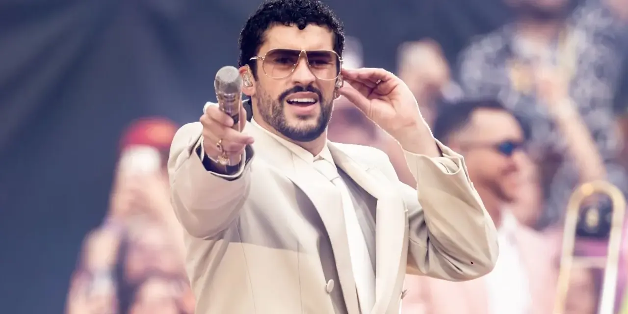 Bad Bunny w beżowym garniturze, z mikrofonem w dłoni, czuje energię tłumu.