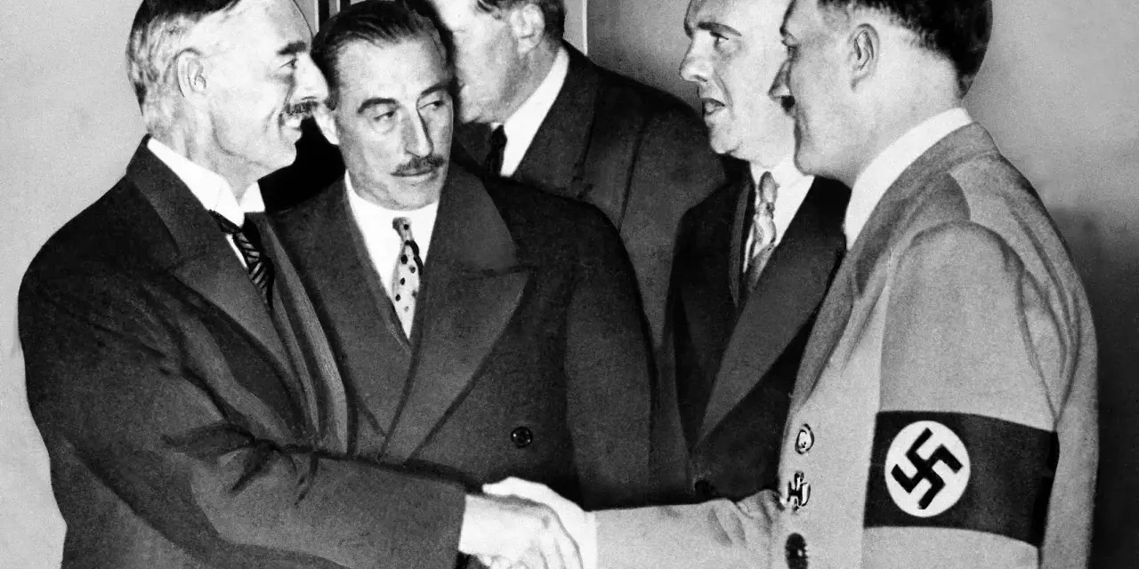 Neville Chamberlain y Adolf Hitler se dan la mano en la conferencia de Múnich, un momento clave de la historia.