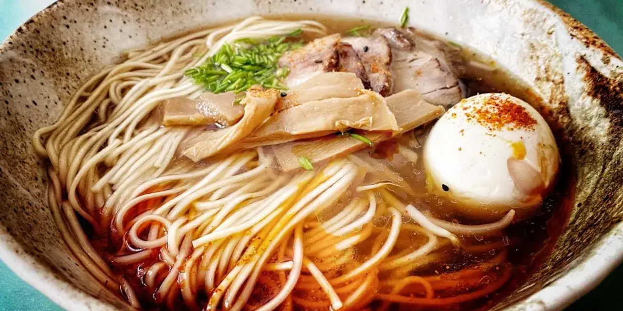 Miseczka aromatycznego ramenu z makaronem, jajkiem, mięsem i bambusem. Idealny przepis, jak zrobić ramen.