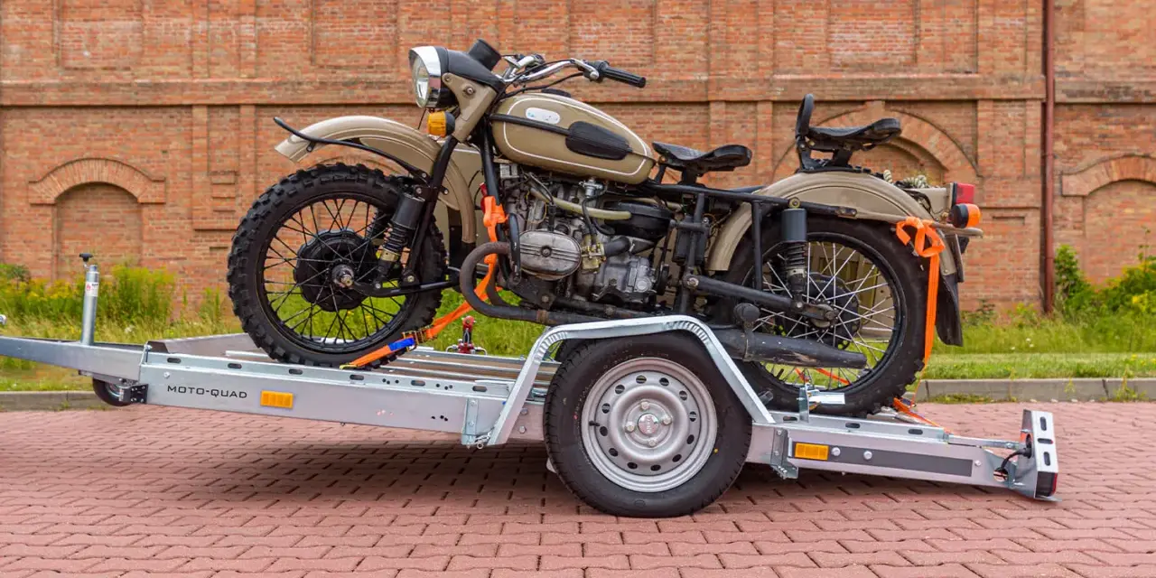 Jak przewieźć motocykl? Na przyczepie MOTO-QUAD, zabezpieczony pasami. Klasyczny motocykl z wózkiem bocznym czeka na transport.
