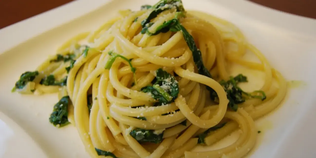 Bucatini z zielonymi liśćmi i parmezanem, pyszne danie, które może konkurować ze spaghetti.