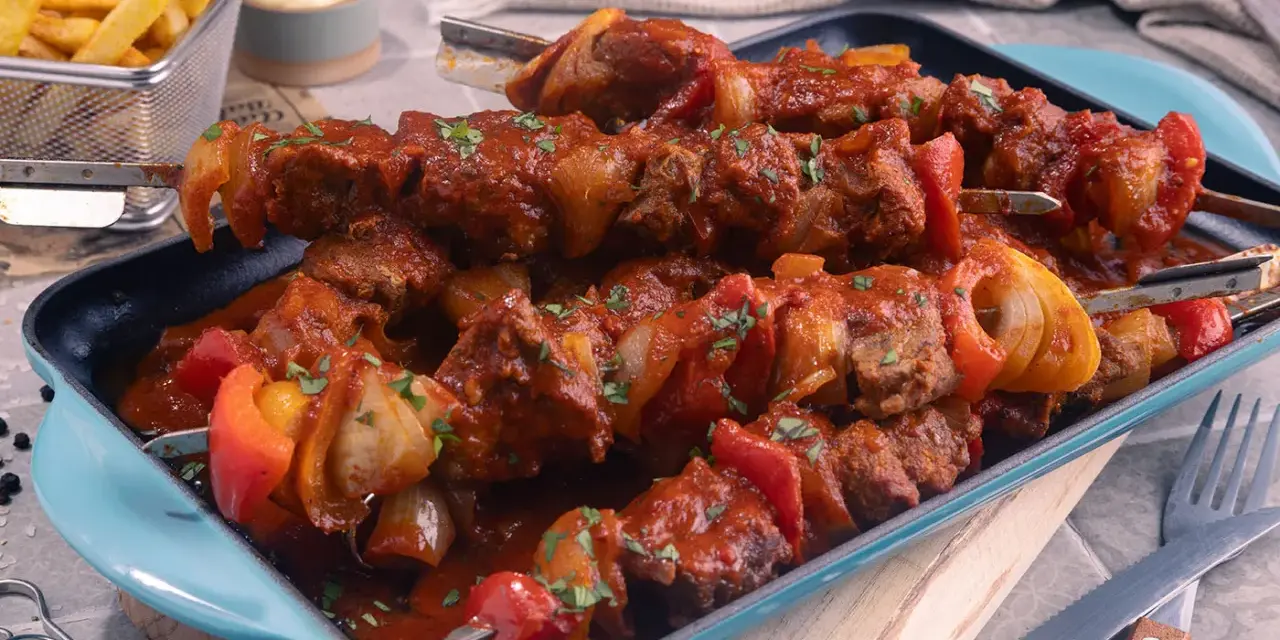 Herzhaftes Schaschlik im original Rezept-Stil, mit saftigem Fleisch, Paprika und Zwiebeln in würziger Sauce. Dazu knusprige Pommes.