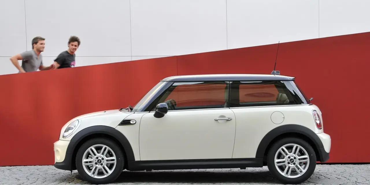 Biały Mini Cooper 1.6 120 KM, z dwoma mężczyznami w tle. Czy są jakieś wady?