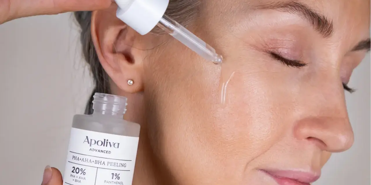 Droppe av aha-syra ansikte-serum appliceras på huden. En flaska med peeling syns i förgrunden.