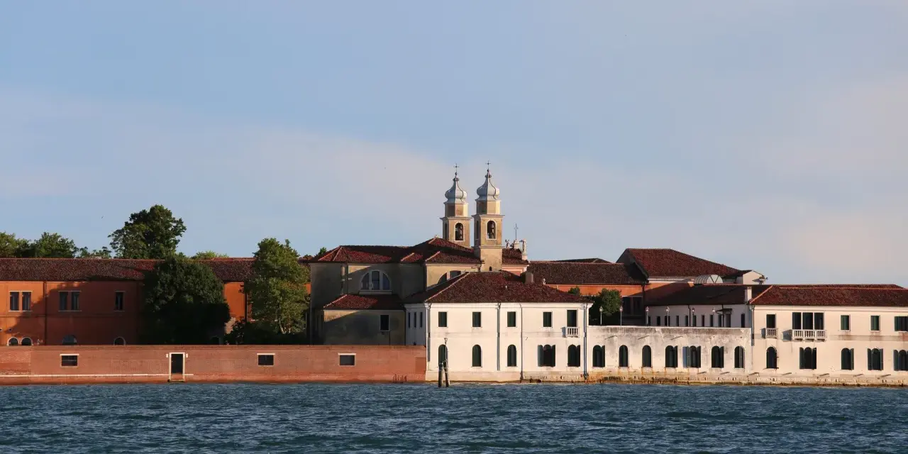 Edifici storici sul canale, tra cui una chiesa con due campanili, che un tempo ospitavano il museo del manicomio di Venezia.