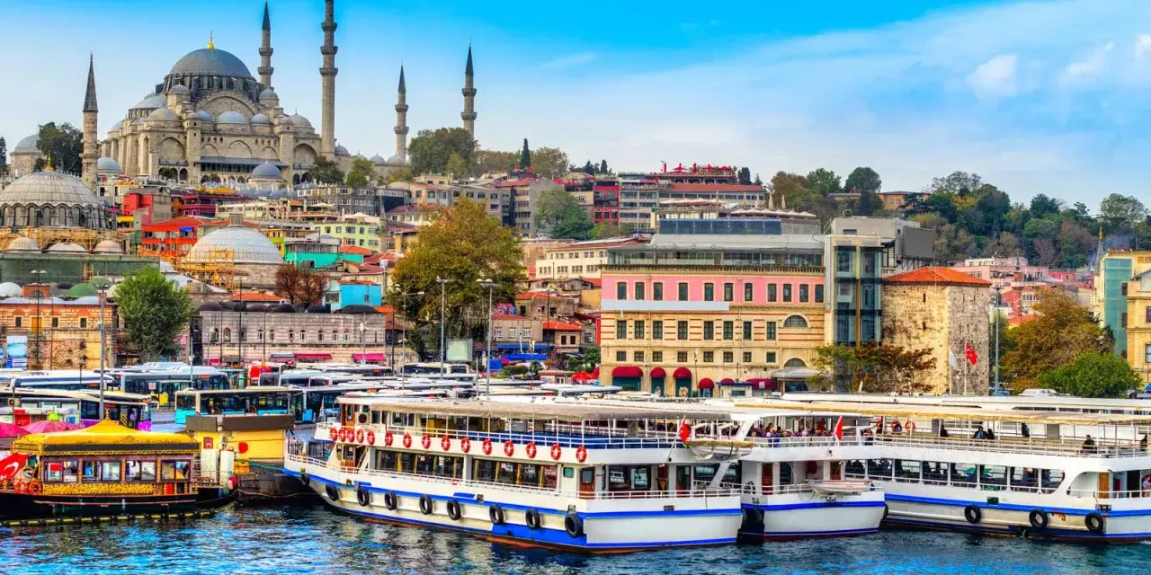 A vibrant cityscape of Istanbul, with the Suleymaniye Mosque dominating the skyline. Ferries and buses line the waterfront, ready for a 3-day Istanbul adventure.