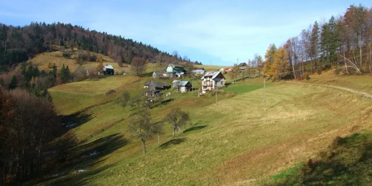 Jesienne krajobrazy Krynica Zdrój szczyty. Domy na zboczach, lasy i łąki.
