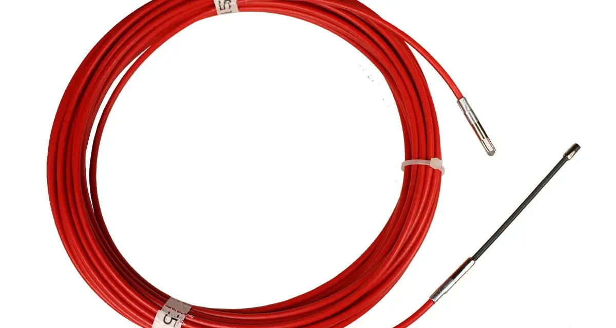 Un passe-fil rouge enroulé, prêt à être utilisé pour guider des câbles.