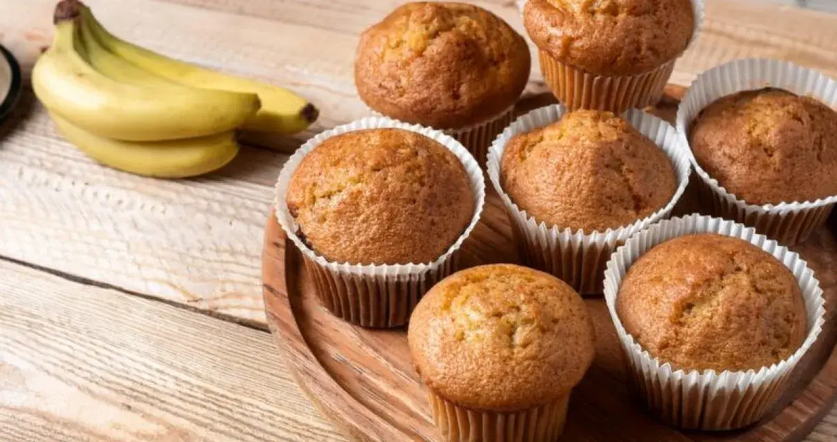 Puszyste babeczki z airfryer, pachnące bananami, ułożone na drewnianej desce.