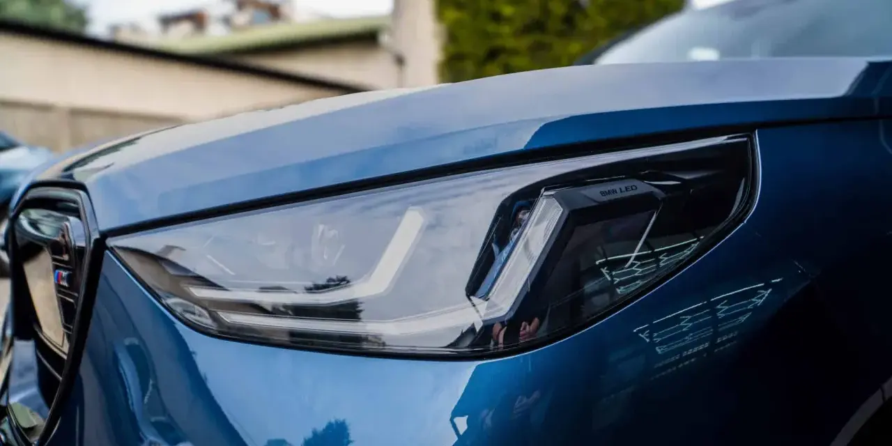 Błyszczący, niebieski lakier BMW z reflektorem LED. To właśnie autodetailing co to znaczy, że samochód wygląda jak nowy.