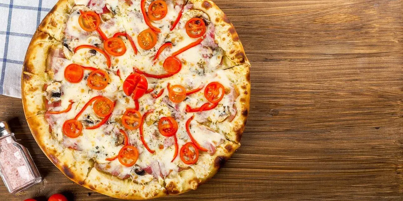 Apetyczna pizza z pomidorkami i papryką, idealna na wieczór. Czy zastanawiałeś się nad pizza hut kalorie?