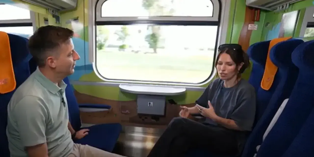 Rozmowa w wagonie z kolorowymi grafikami, być może w ramach specjalnego **metro programu** dla dzieci.