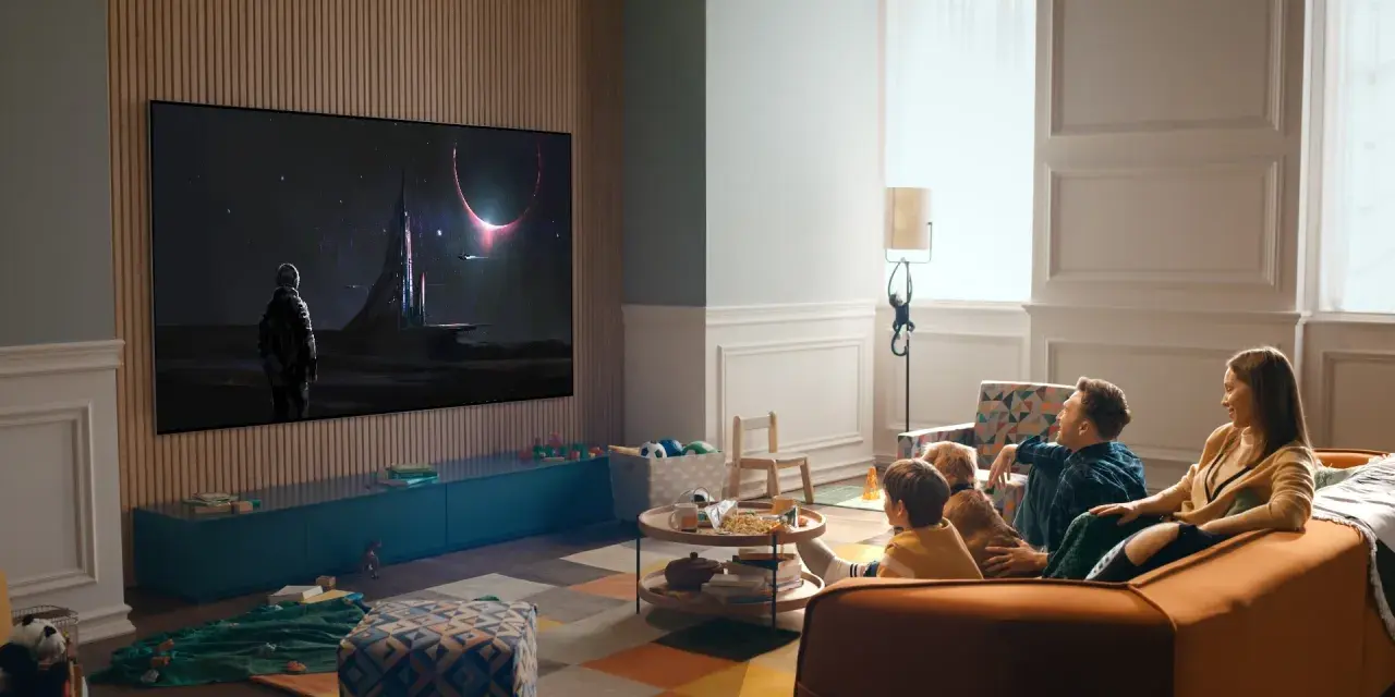 Familj tittar på en rymdfilm på TV:n, kanske via iptv tele2. En astronaut står framför en futuristisk stad under en solförmörkelse.