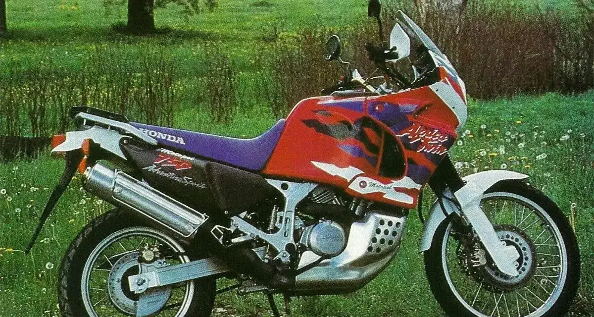 Honda Africa Twin 750 Adventure Sports na tle łąki. Choć to legendarny motocykl, warto znać jego wady przed zakupem.