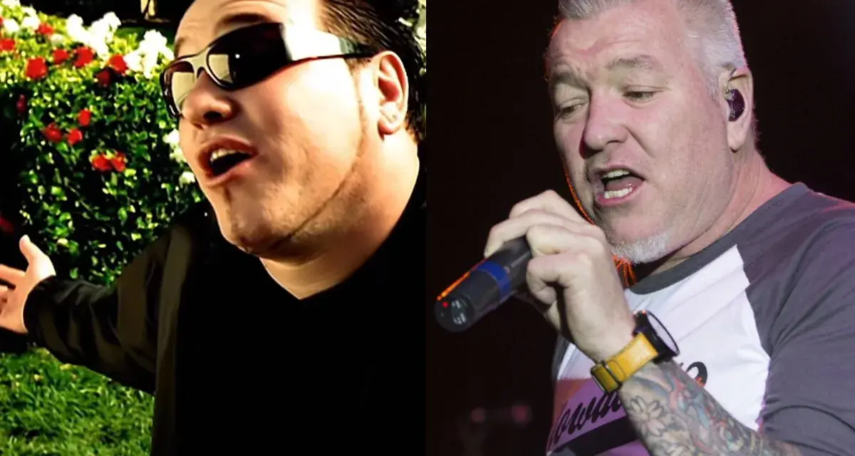 Steven Harwell w okularach przeciwsłonecznych śpiewa na tle ogrodu, obok Steven Harwell z tatuażami trzyma mikrofon na scenie.