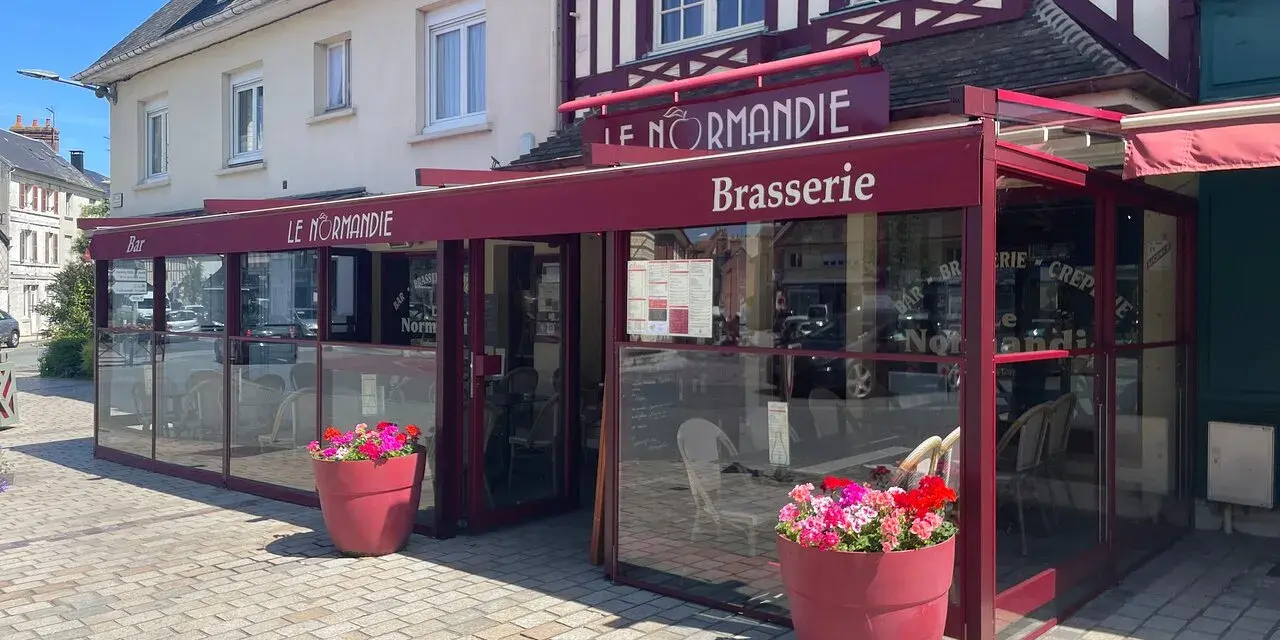 Brasserie Le Normandie, un lieu idéal pour déguster un bon pont l'évêque, fromage au goût unique. Fleurs colorées devant.
