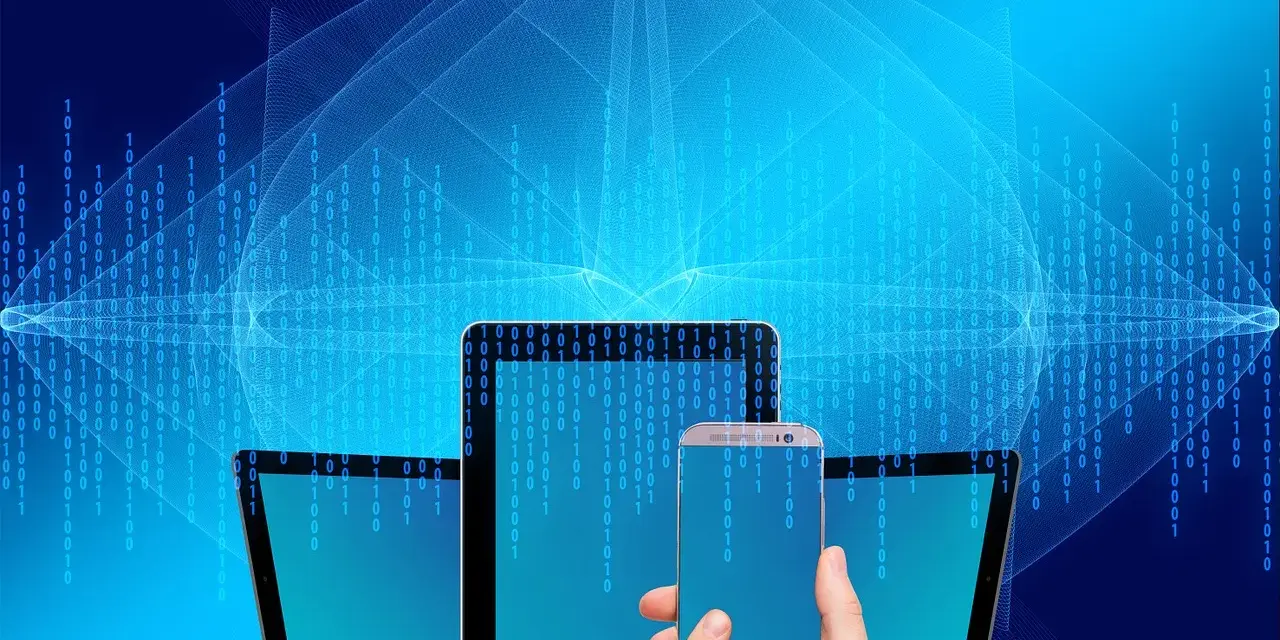 Grafiki bez praw autorskich: nowoczesne urządzenia (smartfon, tablet) na tle cyfrowego kodu binarnego.