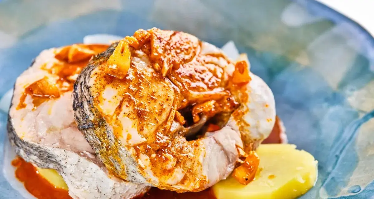 Merluza a la gallega con patatas y salsa de pimentón, un plato tradicional gallego lleno de sabor.