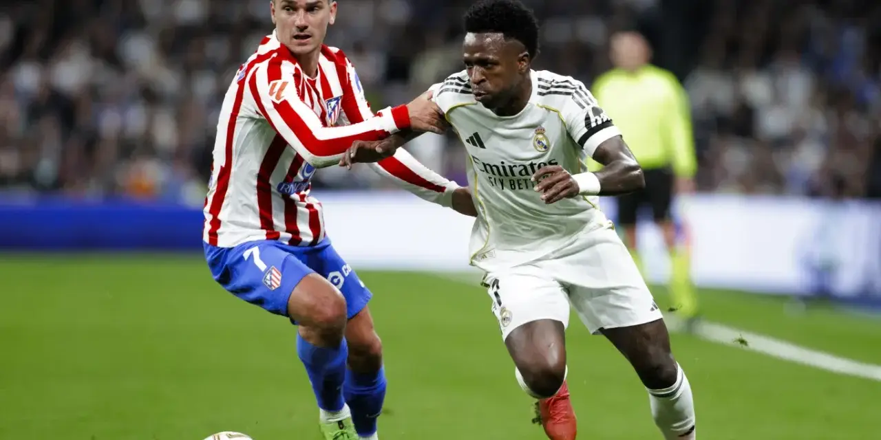 Griezmann z Atletico Madryt walczy o piłkę z Viniciusem z Realu Madryt. Dwa kluby z Madrytu w akcji.