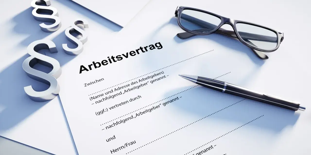 Drei Paragraphen-Symbole, eine Brille und ein Stift liegen auf einem Dokument mit der Überschrift "Arbeitsvertrag". Dies unterstreicht, dass ein Arbeitsvertrag schriftlich sein muss.