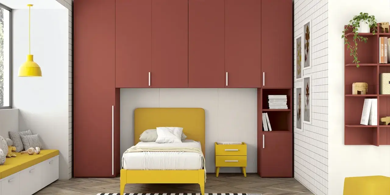 Soluzione perfetta per organizzare armadio a ponte bambini: letto giallo, armadi rossi e tanto spazio per giocare.