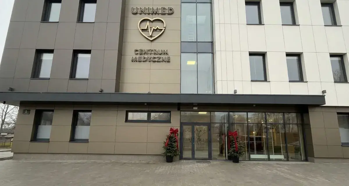 Nowoczesny budynek centrum medycznego Unimed z logo serca i pulsu.