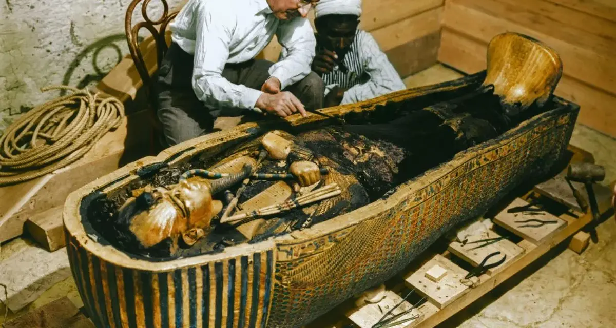 La photo découverte tombeau Toutankhamon : des archéologues examinent la momie dans son sarcophage orné.