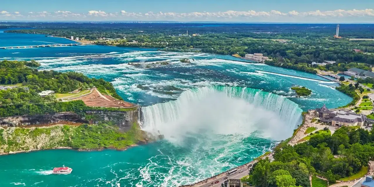 Potężne wodospady Niagara w pełnej krasie, gdzie jest niagara, z turkusową wodą i zielonymi brzegami.