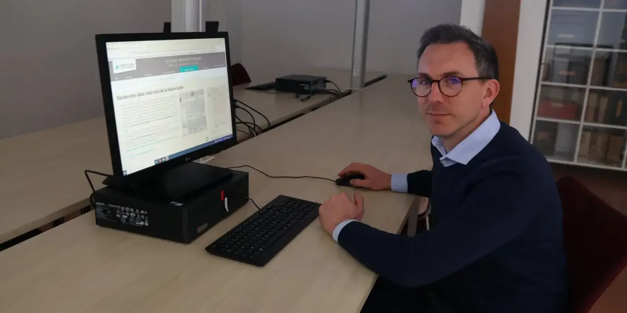 Un homme recherche dans l'état civil de la Haute-Loire sur un ordinateur.