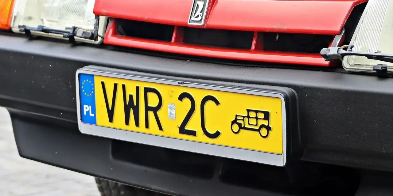 Czerwony grill z logo, reflektor i żółta tablica rejestracyjna z napisem VWR 2C oraz symbolem starego samochodu. To jest rejestracja dw.