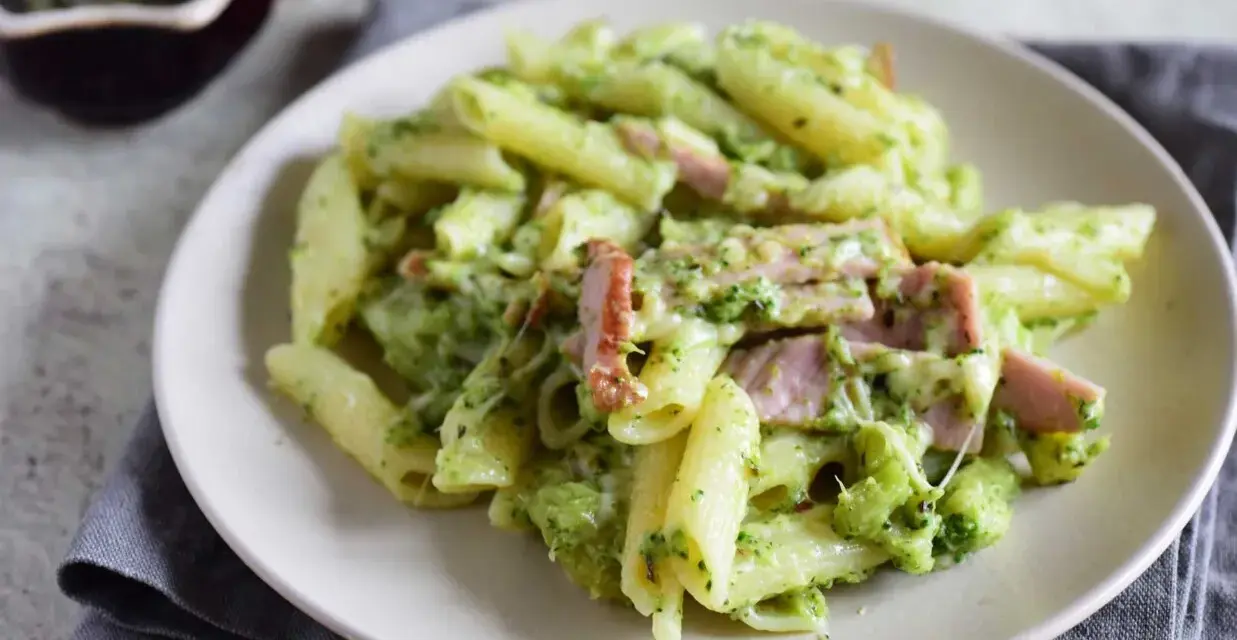 Penne z brokułami i kawałkami szynki w kremowym sosie śmietanowym, posypane serem. Pyszne danie, które zachwyci każdego.