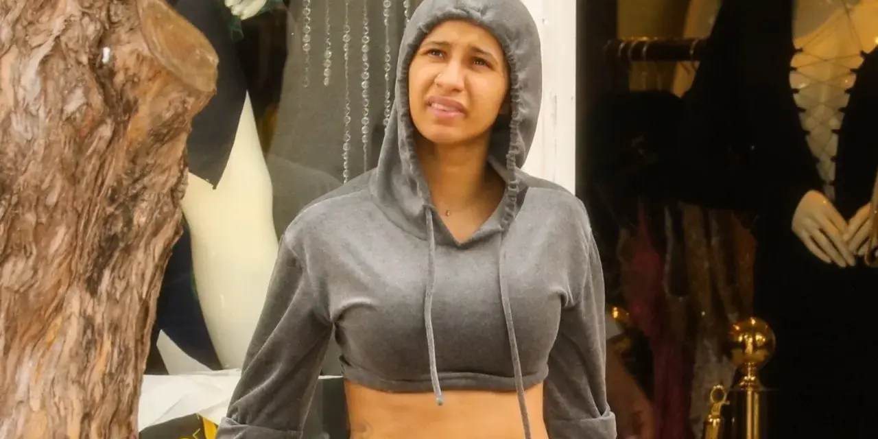Cardi B trägt einen grauen Hoodie und blickt nachdenklich.